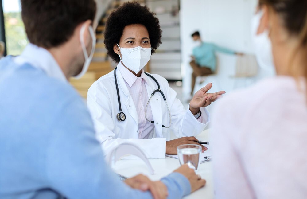 African American female doctor having consultations with a couple during coronavirus epidemic