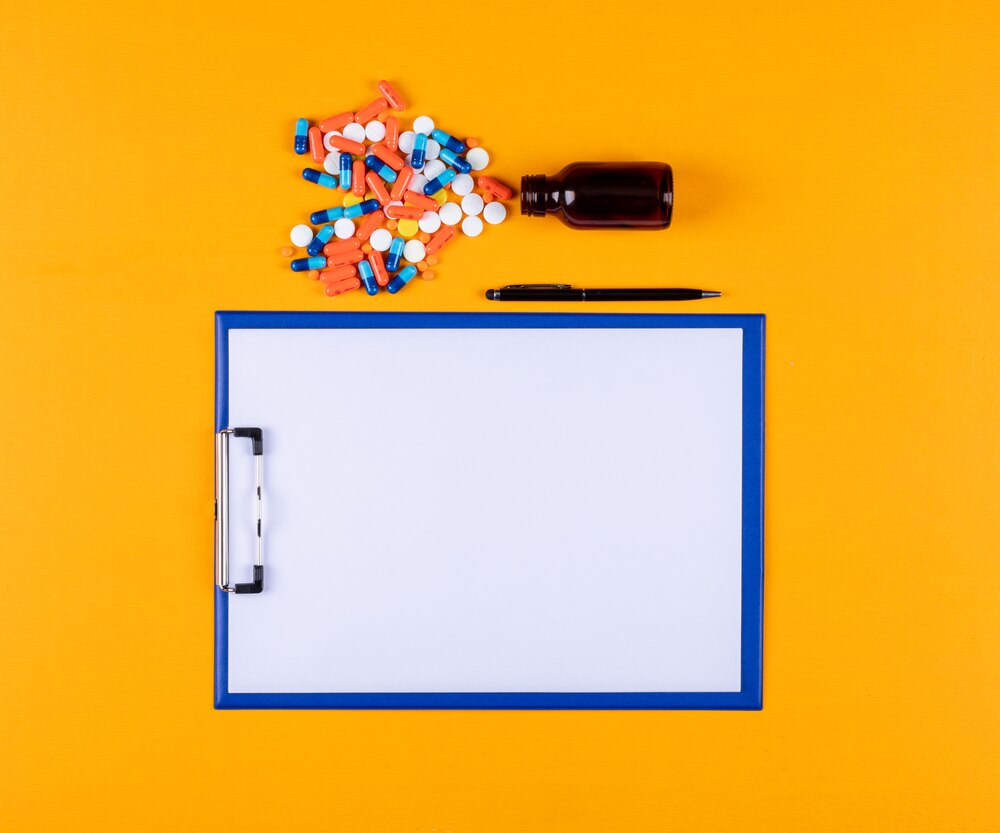 Top view of pills with paper holder and pen